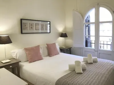a bedroom with a large white bed with a window at CON GRACIA in Barcelona