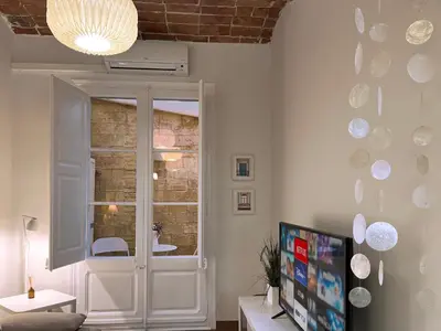 a living room with a tv and a window at CON GRACIA in Barcelona