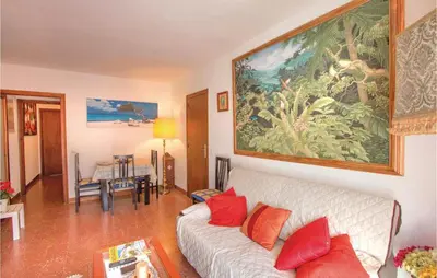 a living room with a white couch and a large painting on the wall at Stunning Apartment In Pineda De Mar in Pineda de Mar