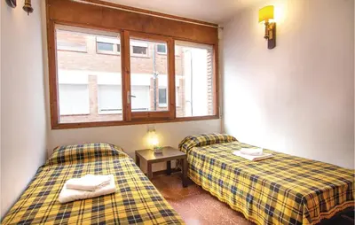 two beds in a small room with a window at Stunning Apartment In Pineda De Mar in Pineda de Mar