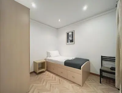 a small bedroom with a bed and a chair at Stay U-nique Apartments Calabria in Barcelona