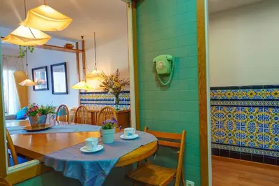 a dining room with a table and a blue tile wall at Aquamarine Terrace Apartment by Hello Homes Sitges in Sitges