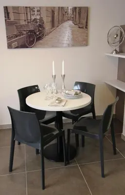 a dining room table with black chairs and a white table at Pierre & Vacances Barcelona Sants in Barcelona