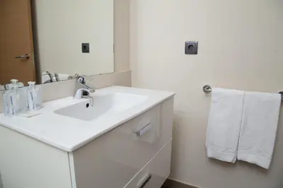 a white bathroom with a sink and a mirror at Pierre & Vacances Barcelona Sants in Barcelona
