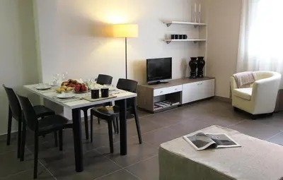 a living room with a table and chairs and a television at Pierre & Vacances Barcelona Sants in Barcelona