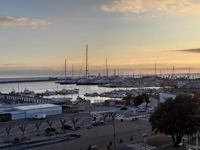 a marina with boats in the water at sunset at Beach Apartment in Vilanova i la Geltrú
