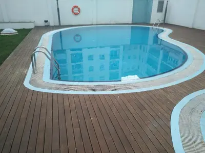a large swimming pool on a wooden deck at Beach Apartment in Vilanova i la Geltrú