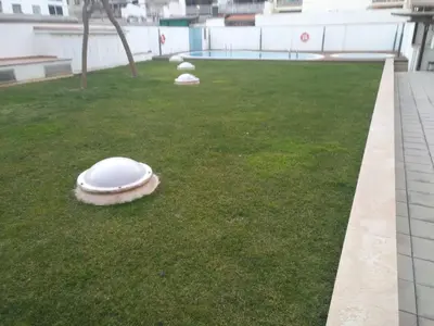 a white frisbee laying on the grass on a building at Beach Apartment in Vilanova i la Geltrú