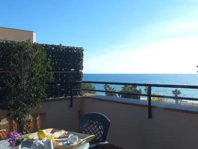 a balcony with a table and a view of the ocean at Hotel Mitus in Canet de Mar
