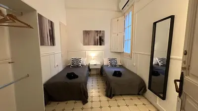 a small bedroom with a bed and a night stand at Des Artistes in Barcelona