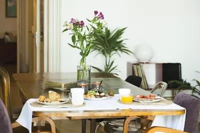 a table with plates of food and a vase of flowers at La Casa Gran B&B in Barcelona