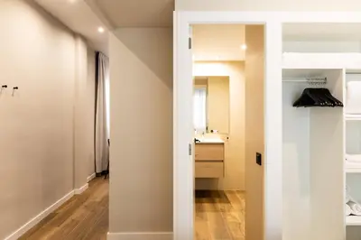 a hallway with a bathroom with a sink and a mirror at Apartamentos Laforja in Barcelona