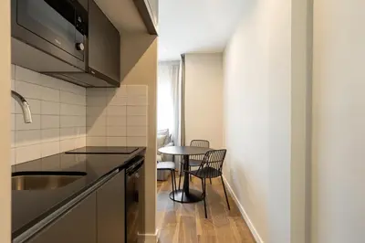 a small kitchen with a table and a small dining room at Apartamentos Laforja in Barcelona