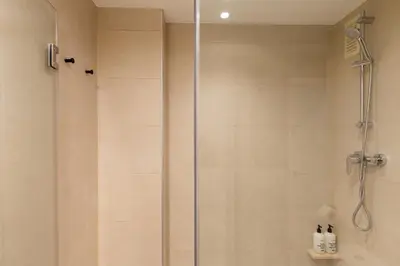 a shower with a glass door in a bathroom at Apartamentos Laforja in Barcelona