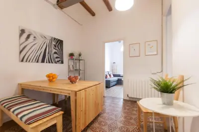 a living room with a wooden table and chairs at Gopal - Piso 7 pax con wifi y calefacción Gracia Barcelona in Barcelona