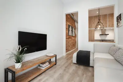 a living room with a white couch and a flat screen tv at Art House Fira Apartments in Barcelona
