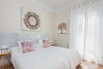 a white bedroom with a white bed and a window at Art House Fira Apartments in Barcelona