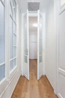 an empty hallway with white walls and an open door at Art House Fira Apartments in Barcelona