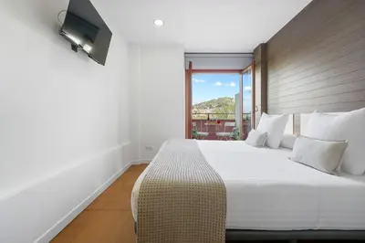a bedroom with a large white bed and a window at Abarco Apartments in Santa Coloma