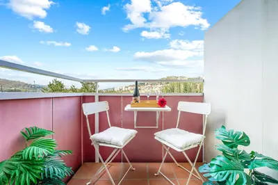a balcony with two chairs and a table on a balcony at Abarco Apartments in Santa Coloma