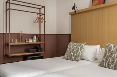 a bedroom with a bed with white sheets and pillows at BYPILLOW Ramblas in Barcelona