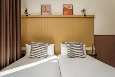 two beds sitting next to each other in a room at BYPILLOW Ramblas in Barcelona