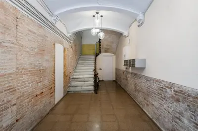 a hallway with stairs and a brick wall at BYPILLOW Ramblas in Barcelona