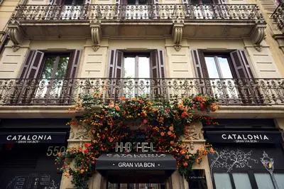 a building with a balcony with flowers on it at Catalonia Gran Via BCN in Barcelona
