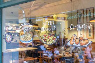a window of a restaurant with signs on it at Sitges CENTRAL - En el corazón de Sitges in Sitges