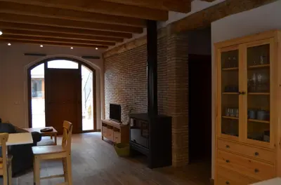 a living room with a brick wall and a stove at Cal Puó Turismo Rural in Collsuspina