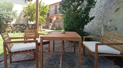 a wooden table and two chairs and a wooden table and chairs at Cal Puó Turismo Rural in Collsuspina