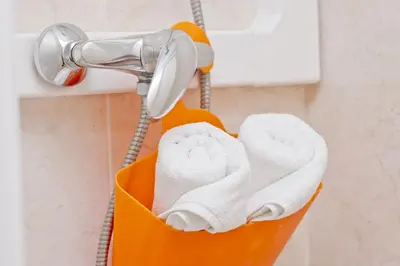 a basket of towels hanging from a shower at Barcelona City Seven Hostal in Barcelona