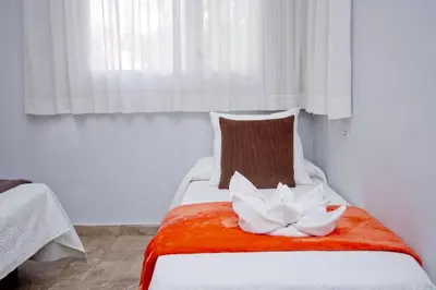 a bed with two pillows on it with a window at Barcelona City Seven Hostal in Barcelona