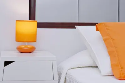 a lamp on a night stand next to a bed at Barcelona City Seven Hostal in Barcelona