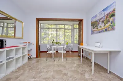 a kitchen with white counters and a table with chairs at Barcelona City Seven Hostal in Barcelona