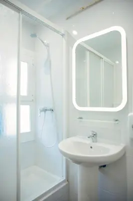 a white bathroom with a sink and a shower at Barcelona City Street Hostal in Barcelona