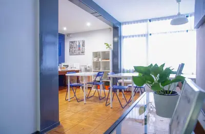 a room with two tables and chairs and a potted plant at Barcelona City Street Hostal in Barcelona