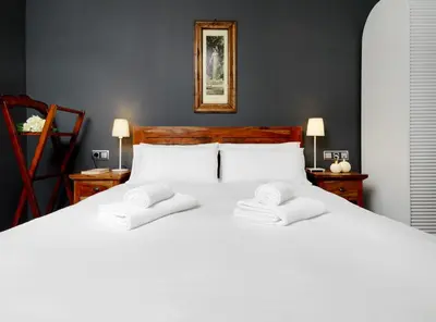 a bedroom with a white bed with two towels on it at Fewdays Barcelona Apartments in Barcelona