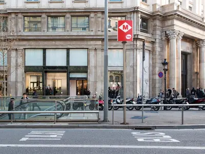 a red sign on a pole in front of a building at Fewdays Barcelona Apartments in Barcelona