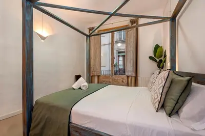 a kitchen with white cabinets and a white refrigerator at La Guarida Suites in Barcelona