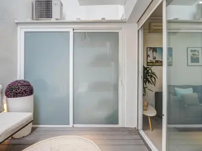 a sliding glass door in a room with a couch at White Center Apartment by Hello Homes Sitges in Sitges