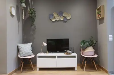 a living room with a tv and two pink chairs at Sagrada Familia Xamfrà in Barcelona
