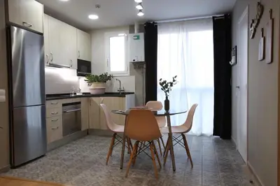 a kitchen with a table and chairs and a refrigerator at Sagrada Familia Xamfrà in Barcelona