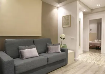 a living room with a gray couch with two pillows at Sagrada Familia Xamfrà in Barcelona