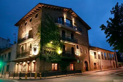a building with ivy growing on the side of it at La Violeta HOTEL SPA & CHILL OUT in Castelltersol