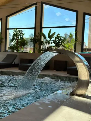 a water fountain in the middle of a swimming pool at La Violeta HOTEL SPA & CHILL OUT in Castelltersol