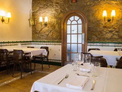 a restaurant with white tables and chairs and a window at La Violeta HOTEL SPA & CHILL OUT in Castelltersol