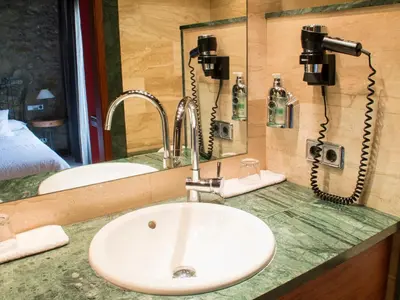 a bathroom counter with a sink and two phones at La Violeta HOTEL SPA & CHILL OUT in Castelltersol