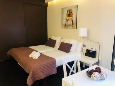 a hotel room with two beds and a table at Barcelona Fifteen central Aparthotel in Barcelona