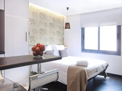 a bedroom with a bed and a table with a bowl of fruit on it at Barcelona Fifteen central Aparthotel in Barcelona